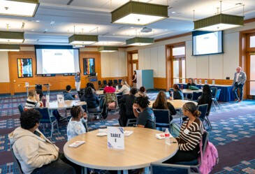 High school students seated at tables during the Ottawa County Gauntlet event at Grand Valley State University's Seidman College of Business.
